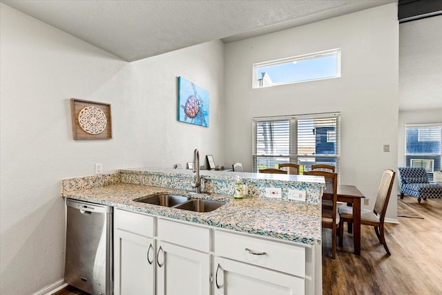 kitchen featuring stainless steel dishwasher, plenty of natural light, white cabinetry, and sink