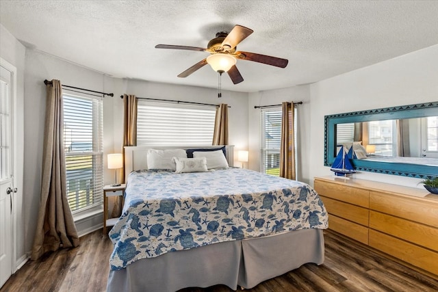 bedroom with a textured ceiling, ceiling fan, and dark hardwood / wood-style floors