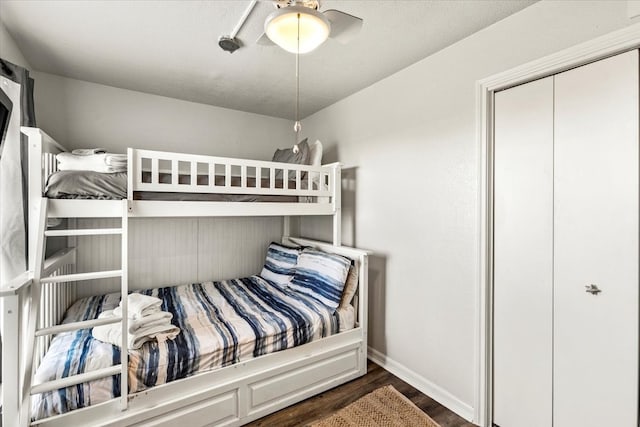 bedroom featuring ceiling fan, dark wood-type flooring, and a closet