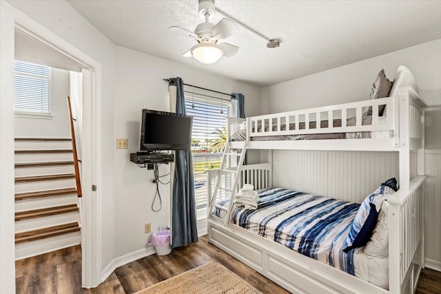 bedroom with ceiling fan, dark hardwood / wood-style flooring, and a textured ceiling