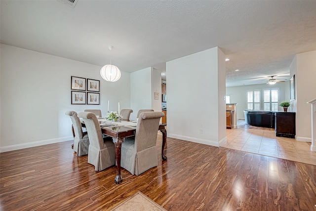 dining space featuring a textured ceiling, light hardwood / wood-style floors, and ceiling fan