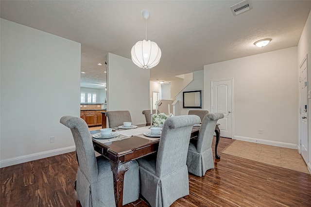 dining area with dark hardwood / wood-style floors and a textured ceiling