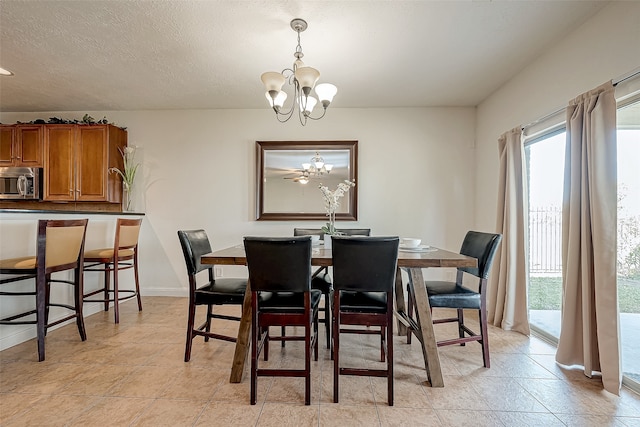 tiled dining area featuring a textured ceiling and a notable chandelier