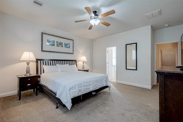 carpeted bedroom with ceiling fan, a textured ceiling, and ensuite bath