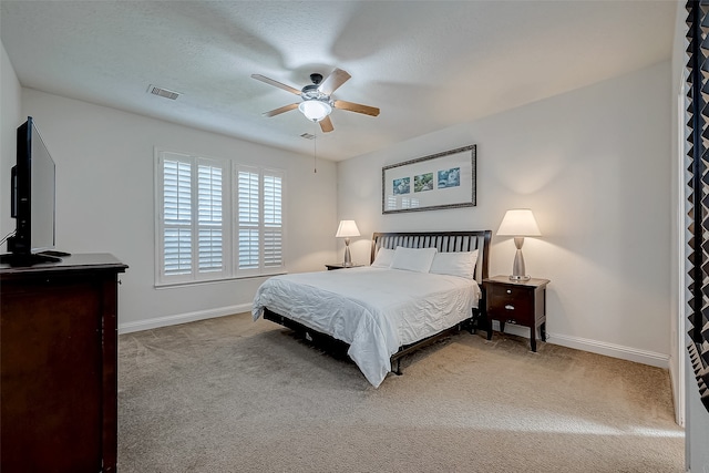 carpeted bedroom with ceiling fan and a textured ceiling