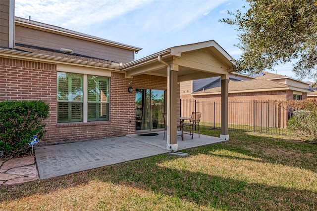 rear view of property with a patio and a lawn