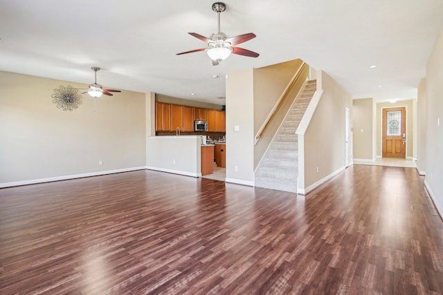 unfurnished living room featuring dark hardwood / wood-style floors and ceiling fan