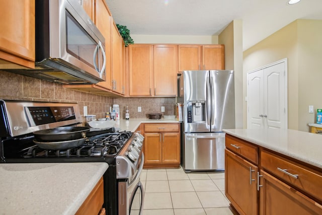 kitchen featuring stainless steel appliances, tasteful backsplash, and light tile patterned flooring