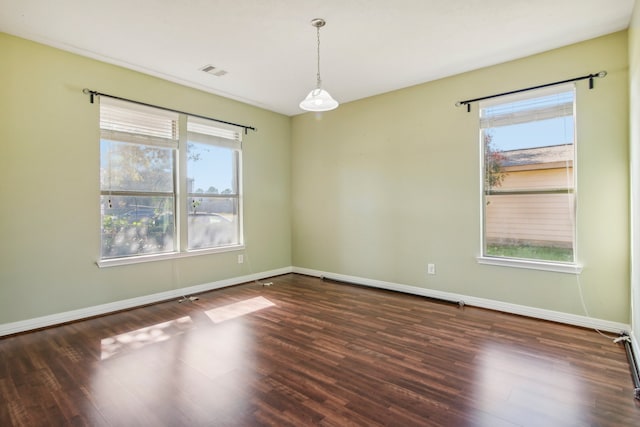 unfurnished room with a wealth of natural light and dark hardwood / wood-style flooring