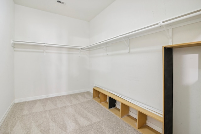 walk in closet featuring light colored carpet