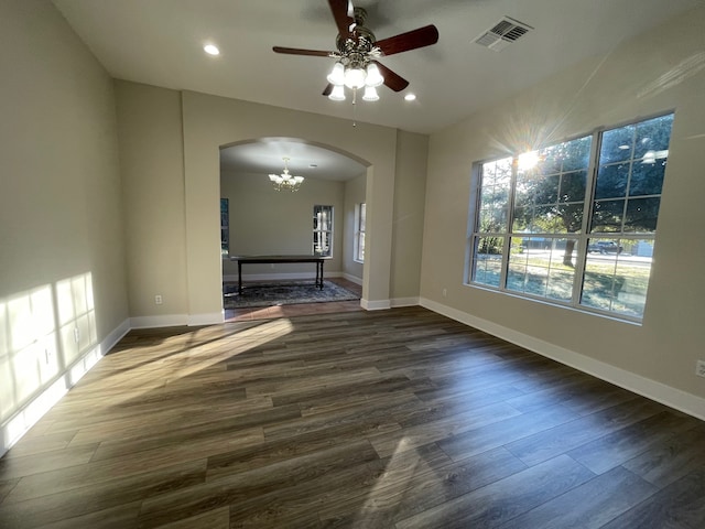 unfurnished living room with dark wood-type flooring and ceiling fan with notable chandelier