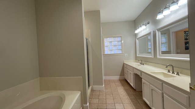 bathroom with tile patterned flooring, vanity, and a washtub