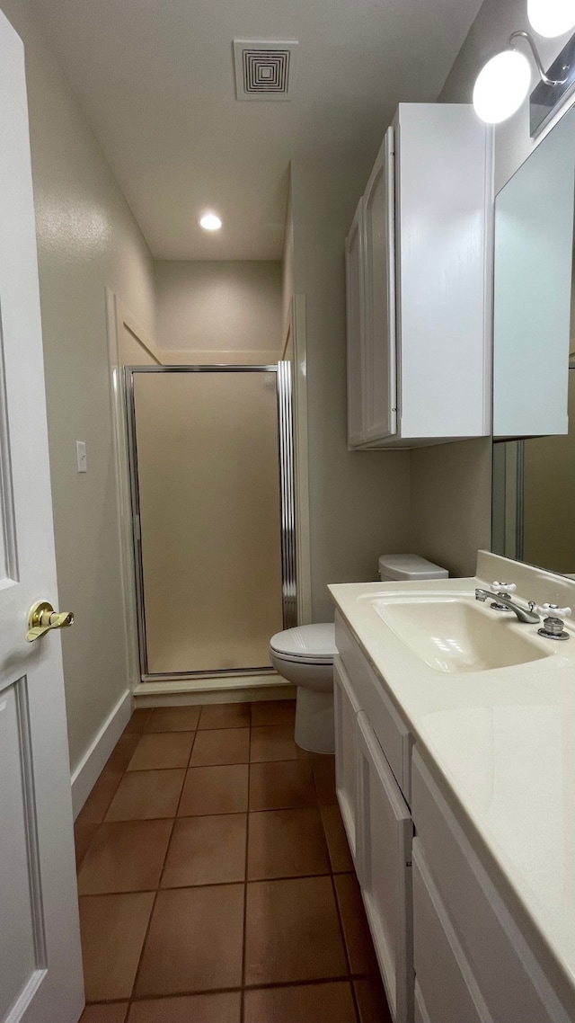 bathroom with tile patterned flooring, vanity, toilet, and an enclosed shower