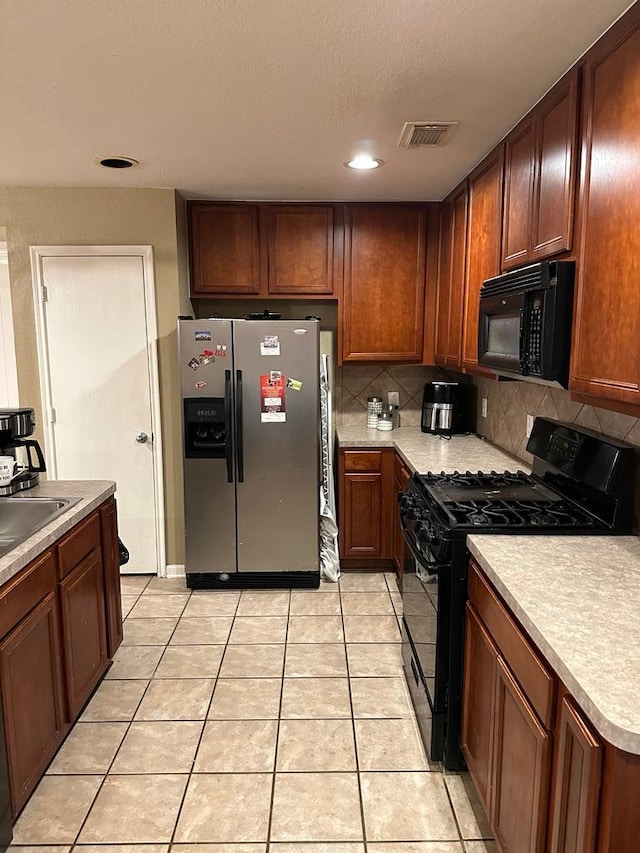 kitchen featuring black appliances, sink, light tile patterned floors, and backsplash