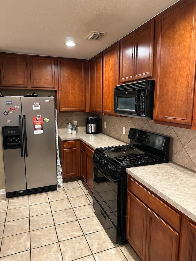 kitchen featuring black appliances, light tile patterned floors, and tasteful backsplash