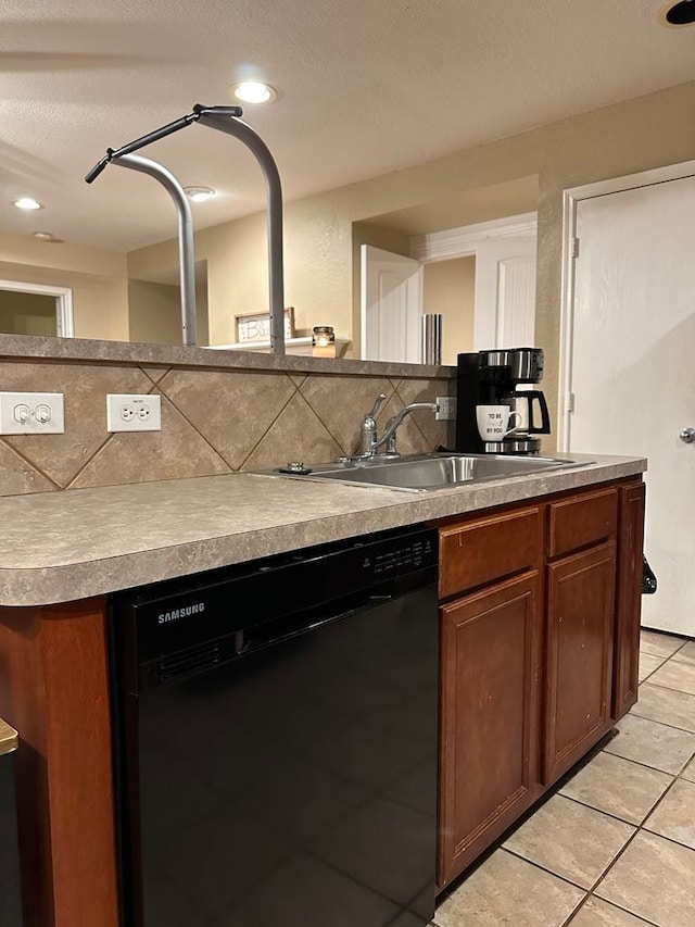 kitchen featuring tasteful backsplash, dishwasher, light tile patterned floors, and sink