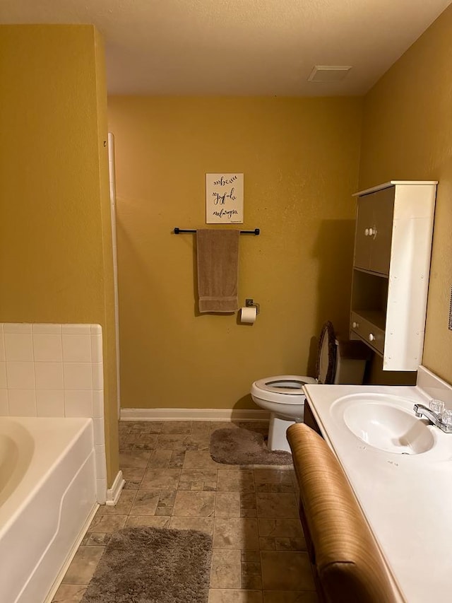 bathroom featuring a bathtub, vanity, and toilet