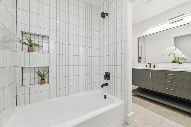 bathroom featuring vanity and tiled shower / bath