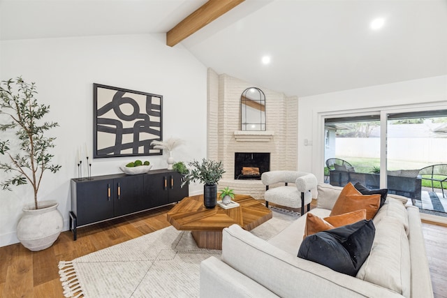 living room with vaulted ceiling with beams, a fireplace, and wood-type flooring