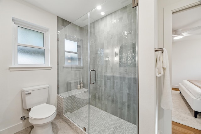 bathroom featuring a shower with shower door, ceiling fan, toilet, and wood-type flooring