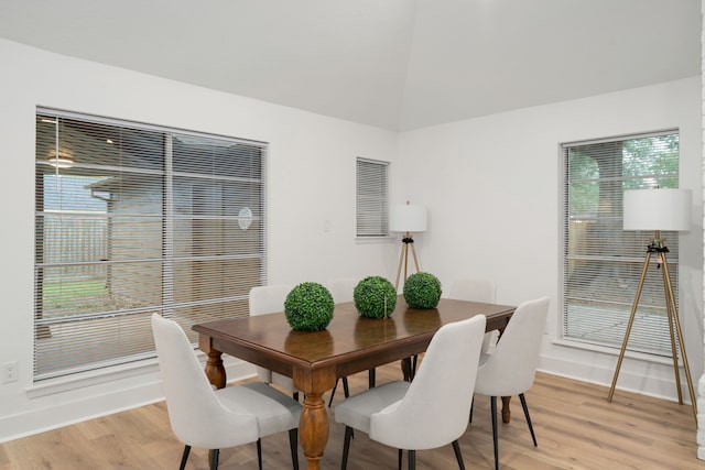 dining room featuring light wood-type flooring and lofted ceiling