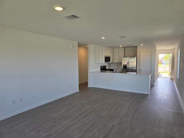 kitchen featuring white cabinets, appliances with stainless steel finishes, sink, dark hardwood / wood-style floors, and kitchen peninsula