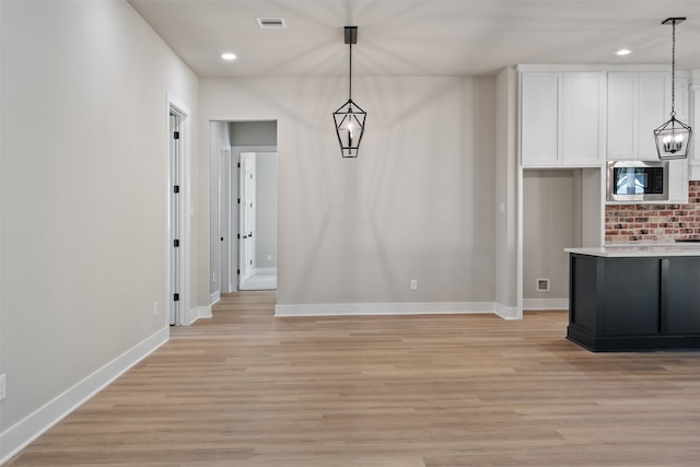 unfurnished dining area featuring light wood-style floors, baseboards, visible vents, and recessed lighting