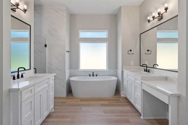 full bath with wood finished floors, two vanities, and a sink