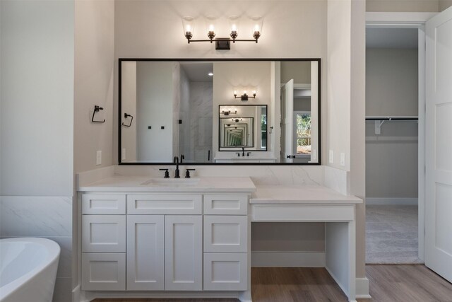 bathroom with plus walk in shower, hardwood / wood-style floors, and vanity