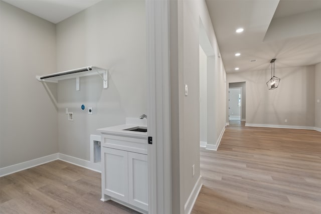 washroom featuring hookup for an electric dryer, light hardwood / wood-style floors, sink, and hookup for a washing machine