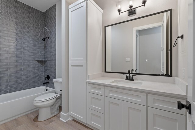 full bathroom with tiled shower / bath combo, toilet, wood-type flooring, and vanity