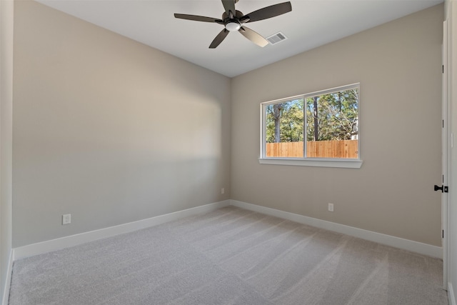 spare room featuring visible vents, baseboards, a ceiling fan, and light colored carpet