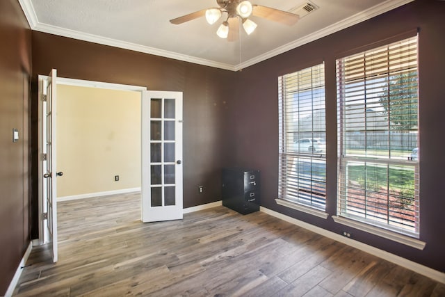 empty room featuring ceiling fan, crown molding, french doors, and hardwood / wood-style flooring