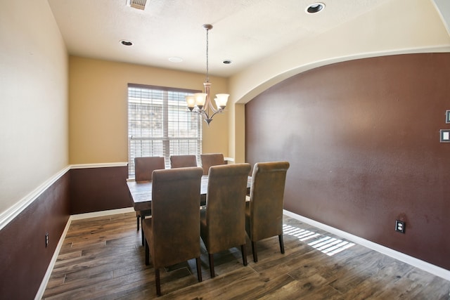 dining space featuring dark hardwood / wood-style floors and an inviting chandelier