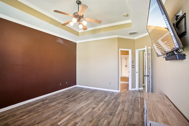 spare room featuring a raised ceiling, crown molding, ceiling fan, and wood-type flooring