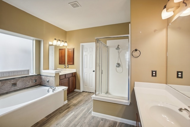 bathroom with separate shower and tub, vanity, and hardwood / wood-style flooring