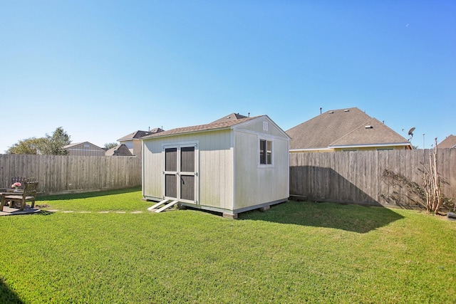 rear view of property with a lawn and a shed