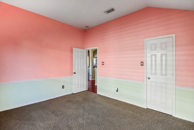 carpeted spare room with lofted ceiling