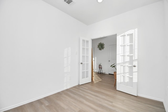 unfurnished room with light hardwood / wood-style flooring and french doors