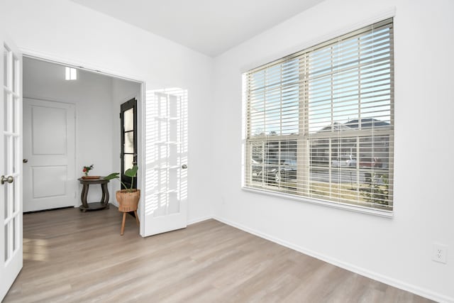 spare room with light hardwood / wood-style flooring and french doors