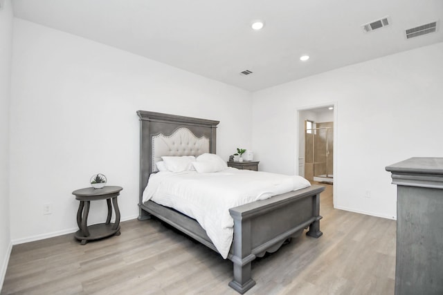 bedroom featuring ensuite bath and hardwood / wood-style flooring