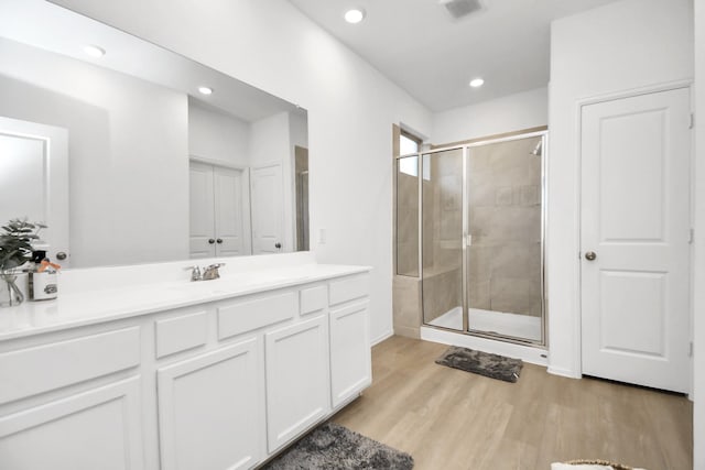 bathroom with vanity, wood-type flooring, and walk in shower