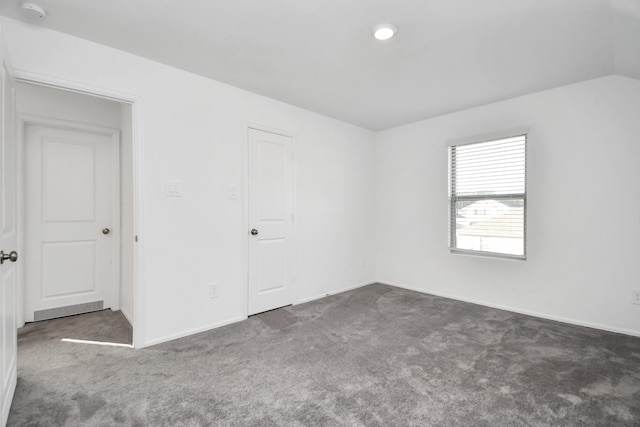 spare room featuring dark colored carpet