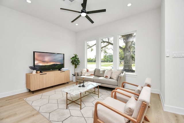 living room featuring a wealth of natural light, ceiling fan, and light wood-type flooring