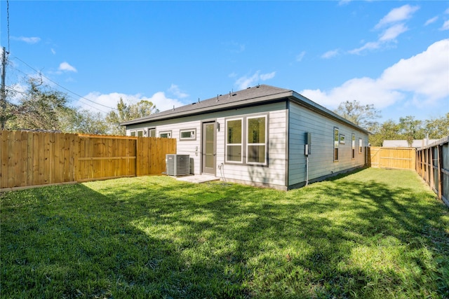 back of property featuring cooling unit and a lawn