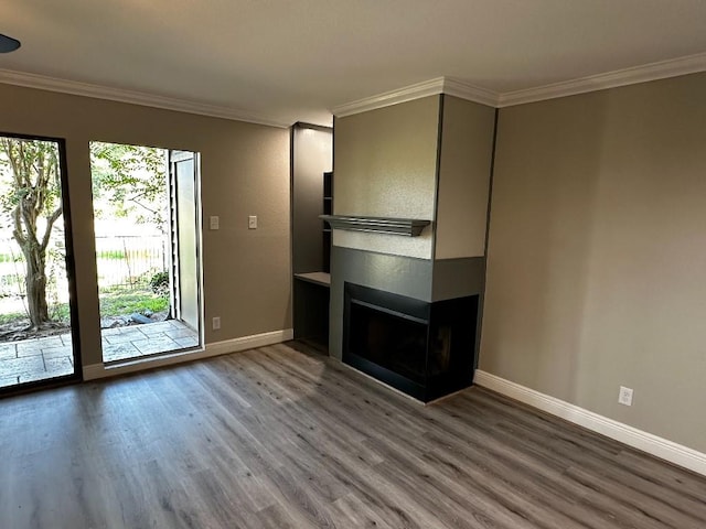 unfurnished living room featuring a healthy amount of sunlight, wood-type flooring, and crown molding