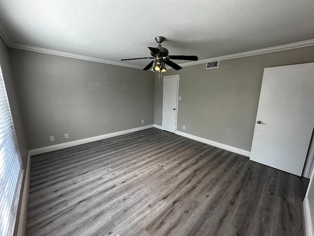 spare room featuring a textured ceiling, crown molding, and dark hardwood / wood-style floors