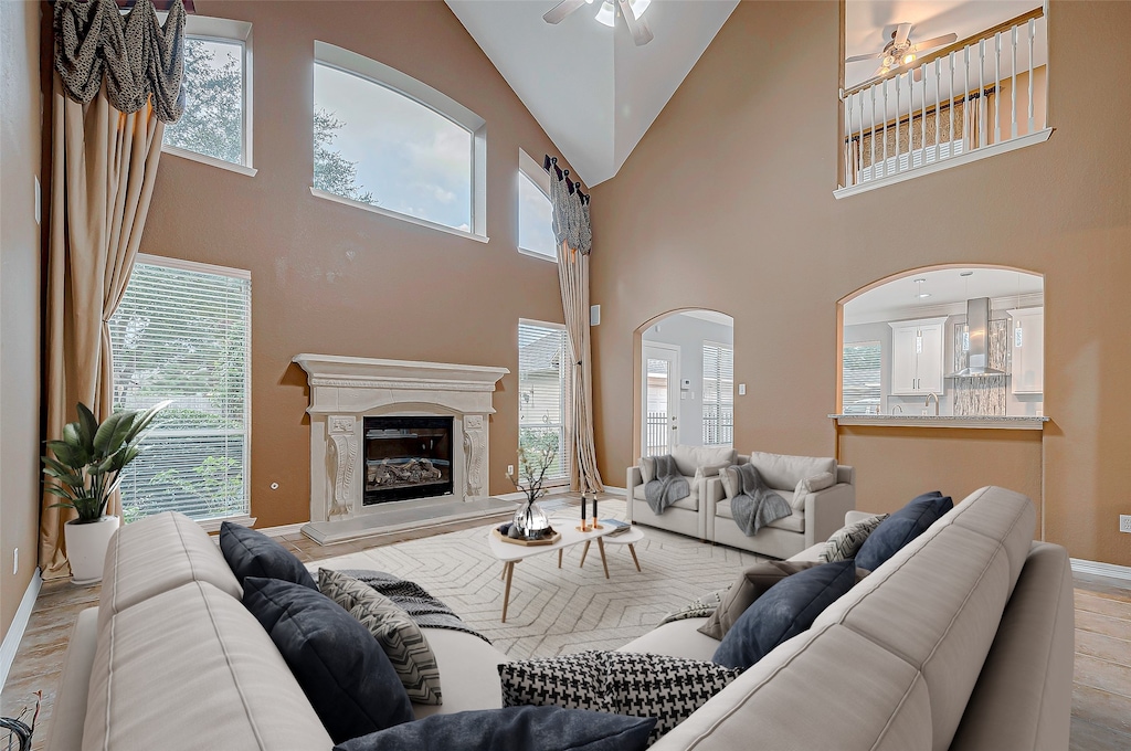 living room featuring light wood-type flooring, high vaulted ceiling, plenty of natural light, and ceiling fan