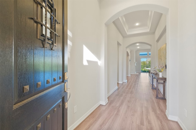 foyer entrance with hardwood / wood-style flooring, ornamental molding, and a tray ceiling