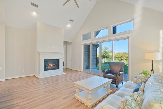 living room featuring ceiling fan, high vaulted ceiling, and light wood-type flooring